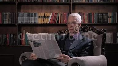 《快乐、成熟、英俊的男人》的画像：在图书馆的眼镜里看报纸，<strong>还有</strong>很多书